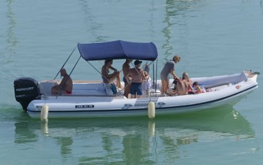 İtalya, Sicilya, Akdeniz, Marina di Ragusa (Ragusa Eyaleti); 4 Ağustos 2019, limanda lastik botta insanlar - Editörden