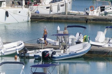 İtalya, Sicilya, Akdeniz, Marina di Ragusa (Ragusa Eyaleti); 7 Ağustos 2019' da limanda insanlar, motorlu tekneler ve lüks yatlar - Editörden