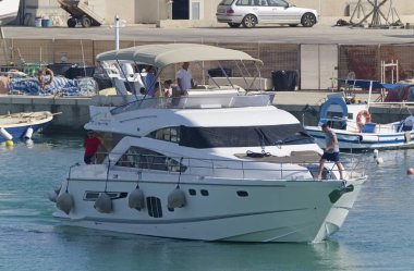 İtalya, Sicilya, Akdeniz, Marina di Ragusa (Ragusa Eyaleti); 9 Ağustos 2019, limanda lüks bir yatta insanlar - Editörden