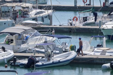 İtalya, Sicilya, Akdeniz, Marina di Ragusa (Ragusa Eyaleti); 10 Ağustos 2019' da limanda insanlar, motorlu tekneler ve lüks yatlar - Editörden