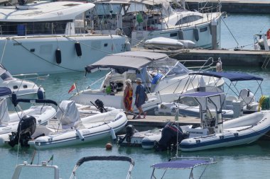 İtalya, Sicilya, Akdeniz, Marina di Ragusa (Ragusa Eyaleti); 10 Ağustos 2019' da limanda insanlar, motorlu tekneler ve lüks yatlar - Editörden