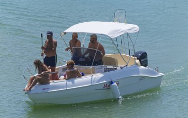 İtalya, Sicilya, Akdeniz, Marina di Ragusa (Ragusa Eyaleti); 10 Ağustos 2019, limanda bir motorlu teknede insanlar - Editörden