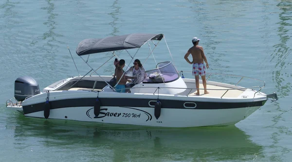 İtalya, Sicilya, Akdeniz, Marina di Ragusa (Ragusa Eyaleti); 11 Ağustos 2019, limanda bir motorlu teknede insanlar - Editörden