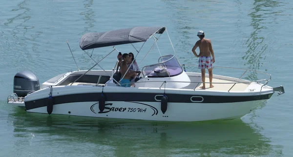 İtalya, Sicilya, Akdeniz, Marina di Ragusa (Ragusa Eyaleti); 11 Ağustos 2019, limanda bir motorlu teknede insanlar - Editörden