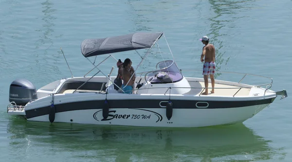 İtalya, Sicilya, Akdeniz, Marina di Ragusa (Ragusa Eyaleti); 11 Ağustos 2019, limanda bir motorlu teknede insanlar - Editörden