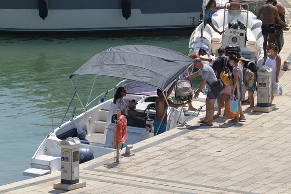 İtalya, Sicilya, Akdeniz, Marina di Ragusa (Ragusa Eyaleti); 11 Ağustos 2019, limanda bir motorlu teknede insanlar - Editörden