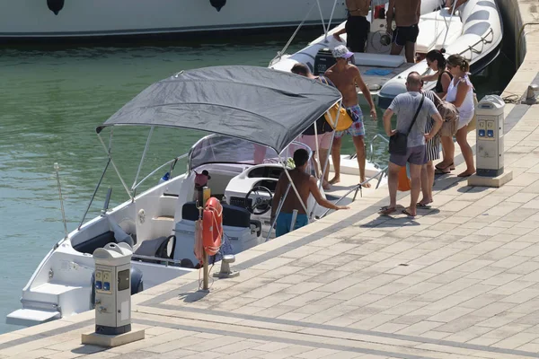 İtalya, Sicilya, Akdeniz, Marina di Ragusa (Ragusa Eyaleti); 11 Ağustos 2019, limanda bir motorlu teknede insanlar - Editörden