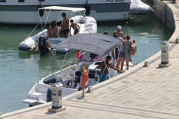 İtalya, Sicilya, Akdeniz, Marina di Ragusa (Ragusa Eyaleti); 11 Ağustos 2019, limanda bir motorlu teknede insanlar - Editörden