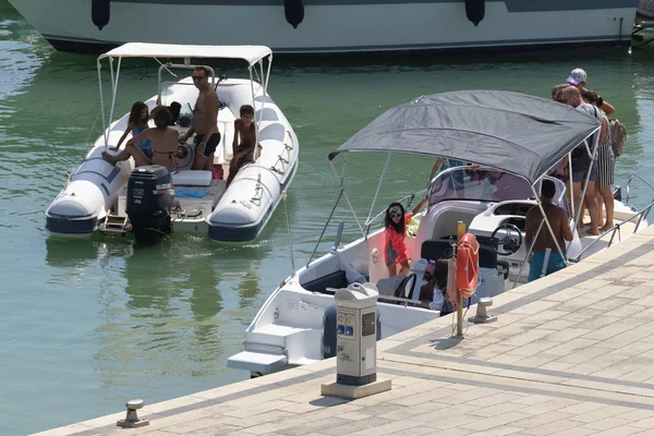 İtalya, Sicilya, Akdeniz, Marina di Ragusa (Ragusa Eyaleti); 11 Ağustos 2019, limanda bir motorlu teknede insanlar - Editörden