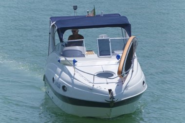 İtalya, Sicilya, Akdeniz, Marina di Ragusa (Ragusa Eyaleti); 10 Ağustos 2019, limanda bir motorlu teknede adam - Editörden