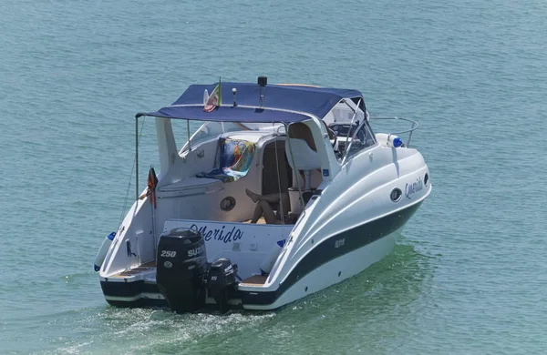 İtalya, Sicilya, Akdeniz, Marina di Ragusa (Ragusa Eyaleti); 10 Ağustos 2019, limanda bir motorlu teknede insanlar - Editörler