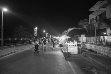 İtalya, Sicilya, Akdeniz, Marina di Ragusa (Ragusa Eyaleti); 14 Ağustos 2019, gece sahilde yürüyen insanlar - Editörden