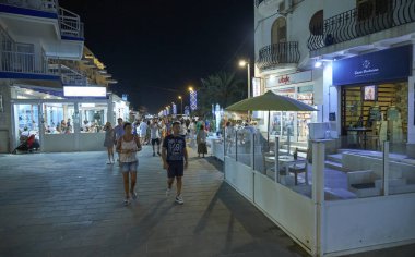 İtalya, Sicilya, Akdeniz, Marina di Ragusa (Ragusa Eyaleti); 14 Ağustos 2019, gece sahilde yürüyen insanlar - Editörden