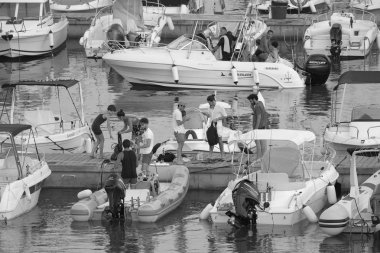 İtalya, Sicilya, Akdeniz, Marina di Ragusa (Ragusa Eyaleti); 19 Ağustos 2019' da limanda insanlar, motorlu tekneler ve lüks yatlar - Editörden