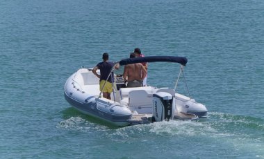 İtalya, Sicilya, Akdeniz, Marina di Ragusa (Ragusa Eyaleti); 20 Ağustos 2019, limanda lastik botta insanlar - Editörden