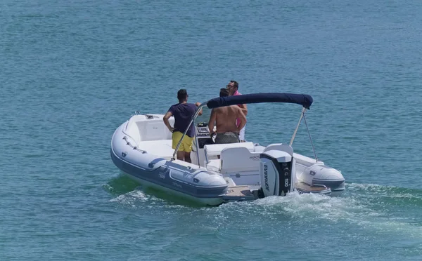 İtalya, Sicilya, Akdeniz, Marina di Ragusa (Ragusa Eyaleti); 20 Ağustos 2019, limanda lastik botta insanlar - Editörden