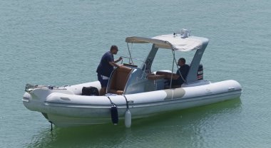 İtalya, Sicilya, Akdeniz, Marina di Ragusa (Ragusa Eyaleti); 27 Ağustos 2019, limanda lastik botta insanlar - Editörden