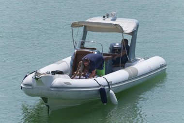 İtalya, Sicilya, Akdeniz, Marina di Ragusa (Ragusa Eyaleti); 27 Ağustos 2019, limanda lastik botta insanlar - Editörden