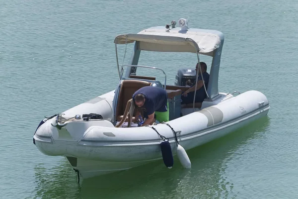 İtalya, Sicilya, Akdeniz, Marina di Ragusa (Ragusa Eyaleti); 27 Ağustos 2019, limanda lastik botta insanlar - Editörden