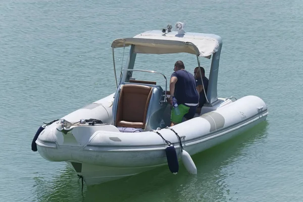 İtalya, Sicilya, Akdeniz, Marina di Ragusa (Ragusa Eyaleti); 27 Ağustos 2019, limanda lastik botta insanlar - Editörden