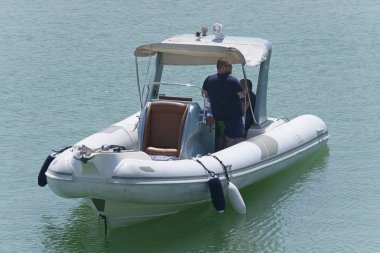 İtalya, Sicilya, Akdeniz, Marina di Ragusa (Ragusa Eyaleti); 27 Ağustos 2019, limanda lastik botta insanlar - Editörden