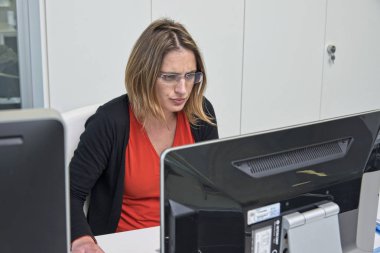 İtalya, Sicilya, Ragusa; 6 Mart 2018,bir ofiste bilgisayarla çalışan kadın - Editörden