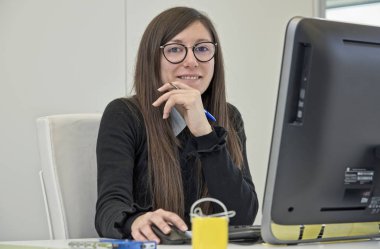 İtalya, Sicilya, Ragusa; 6 Mart 2018,bir ofiste bilgisayarla çalışan kadın - Editörden