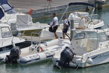 İtalya, Sicilya, Akdeniz, Marina di Ragusa (Ragusa Eyaleti); 30 Ağustos 2019, limanda insanlar ve motorlu tekneler - Editörden