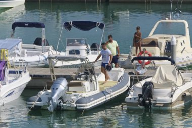 İtalya, Sicilya, Akdeniz, Marina di Ragusa (Ragusa Eyaleti); 31 Ağustos 2019, limanda insanlar ve motorlu tekneler - Editörden