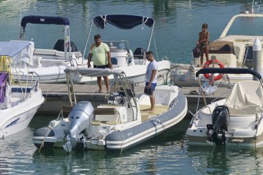 İtalya, Sicilya, Akdeniz, Marina di Ragusa (Ragusa Eyaleti); 31 Ağustos 2019, limanda insanlar ve motorlu tekneler - Editörden