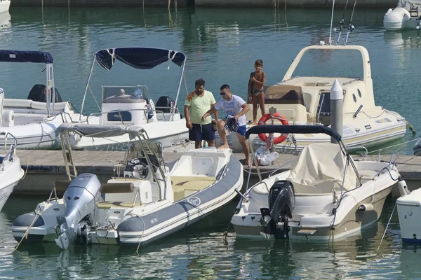 İtalya, Sicilya, Akdeniz, Marina di Ragusa (Ragusa Eyaleti); 31 Ağustos 2019, limanda insanlar ve motorlu tekneler - Editörden