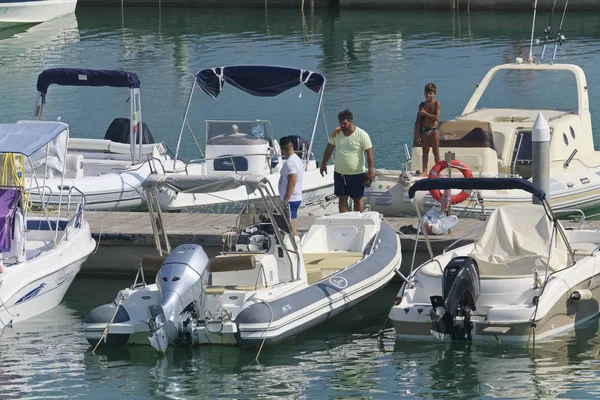 İtalya, Sicilya, Akdeniz, Marina di Ragusa (Ragusa Eyaleti); 31 Ağustos 2019, limanda insanlar ve motorlu tekneler - Editörden
