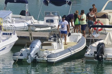 İtalya, Sicilya, Akdeniz, Marina di Ragusa (Ragusa Eyaleti); 31 Ağustos 2019, limanda insanlar ve motorlu tekneler - Editörden