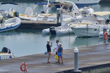 İtalya, Sicilya, Akdeniz, Marina di Ragusa (Ragusa Eyaleti); 1 Eylül 2019' da limanda insanlar, motorlu tekneler ve lüks yatlar - Editörden