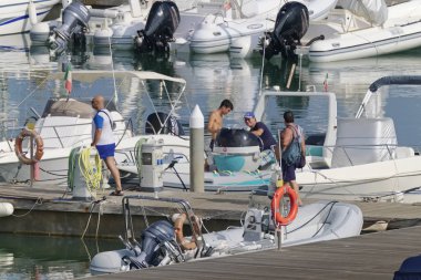 İtalya, Sicilya, Akdeniz, Marina di Ragusa (Ragusa Eyaleti); 1 Eylül 2019' da limanda insanlar, motorlu tekneler ve lüks yatlar - Editörden