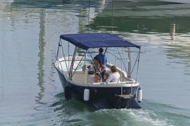 İtalya, Sicilya, Akdeniz, Marina di Ragusa (Ragusa Eyaleti); 1 Eylül 2019, limanda bir motorlu teknede insanlar - Editörden