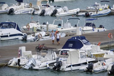 İtalya, Sicilya, Akdeniz, Marina di Ragusa (Ragusa Eyaleti); 3 Eylül 2019' da limanda insanlar, motorlu tekneler ve lüks yatlar - Editörden