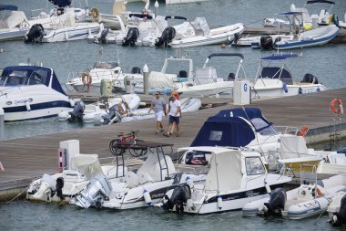 İtalya, Sicilya, Akdeniz, Marina di Ragusa (Ragusa Eyaleti); 3 Eylül 2019' da limanda insanlar, motorlu tekneler ve lüks yatlar - Editörden