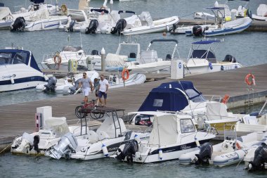 İtalya, Sicilya, Akdeniz, Marina di Ragusa (Ragusa Eyaleti); 3 Eylül 2019' da limanda insanlar, motorlu tekneler ve lüks yatlar - Editörden