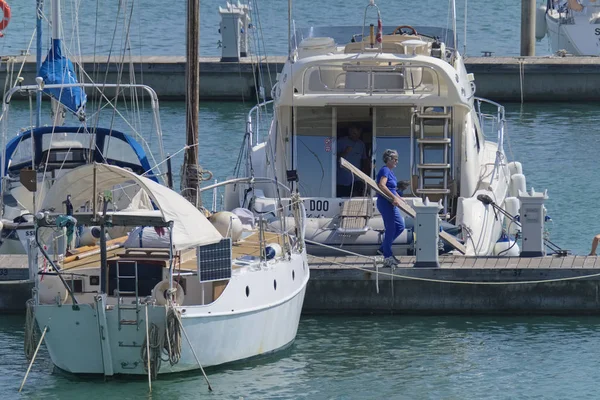 İtalya, Sicilya, Akdeniz, Marina di Ragusa (Ragusa Eyaleti); 6 Eylül 2019' da limanda insanlar ve lüks yatlar - Editörden