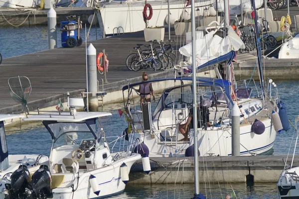 İtalya, Sicilya, Akdeniz, Marina di Ragusa (Ragusa Eyaleti); 6 Eylül 2019, limanda bir yelkenli teknede insanlar - Editörden