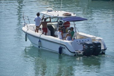 İtalya, Sicilya, Akdeniz, Marina di Ragusa (Ragusa Eyaleti); 15 Eylül 2019, limanda bir motorlu teknede insanlar - Editörden