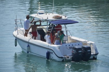 İtalya, Sicilya, Akdeniz, Marina di Ragusa (Ragusa Eyaleti); 15 Eylül 2019, limanda bir motorlu teknede insanlar - Editörden