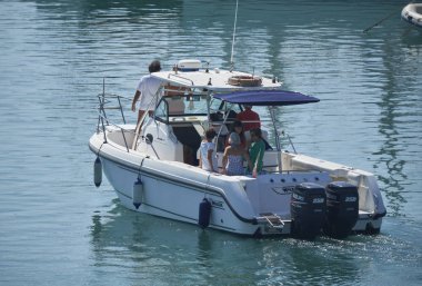 İtalya, Sicilya, Akdeniz, Marina di Ragusa (Ragusa Eyaleti); 15 Eylül 2019, limanda bir motorlu teknede insanlar - Editörden