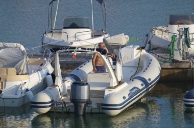 İtalya, Sicilya, Akdeniz, Marina di Ragusa (Ragusa Eyaleti); 15 Eylül 2019, limanda lastik botta adam - Editörden