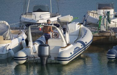 İtalya, Sicilya, Akdeniz, Marina di Ragusa (Ragusa Eyaleti); 15 Eylül 2019, limanda lastik botta adam - Editörden