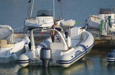 İtalya, Sicilya, Akdeniz, Marina di Ragusa (Ragusa Eyaleti); 15 Eylül 2019, limanda lastik botta adam - Editörden