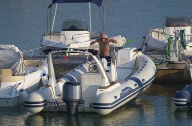 İtalya, Sicilya, Akdeniz, Marina di Ragusa (Ragusa Eyaleti); 15 Eylül 2019, limanda lastik botta adam - Editörden