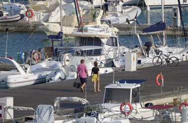 İtalya, Sicilya, Akdeniz, Marina di Ragusa (Ragusa Eyaleti); 18 Eylül 2019, limanda insanlar, motorlu tekneler ve lüks yatlar - Editörden