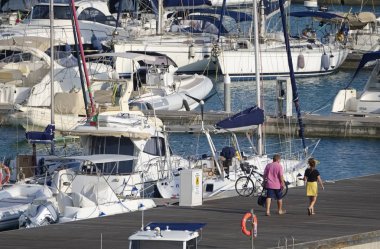 İtalya, Sicilya, Akdeniz, Marina di Ragusa (Ragusa Eyaleti); 18 Eylül 2019, limanda insanlar, motorlu tekneler ve lüks yatlar - Editörden